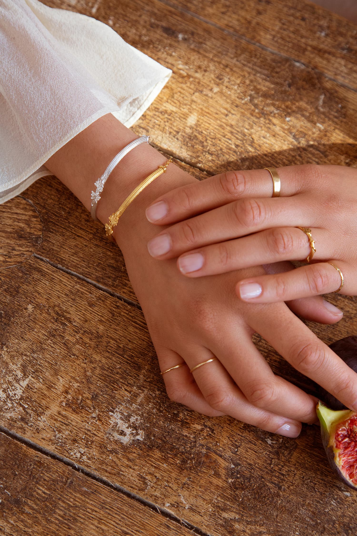 Model wears Fables Hinged Column Bracelet in silver and gold plate with overgrown vine ring and fine gold bands