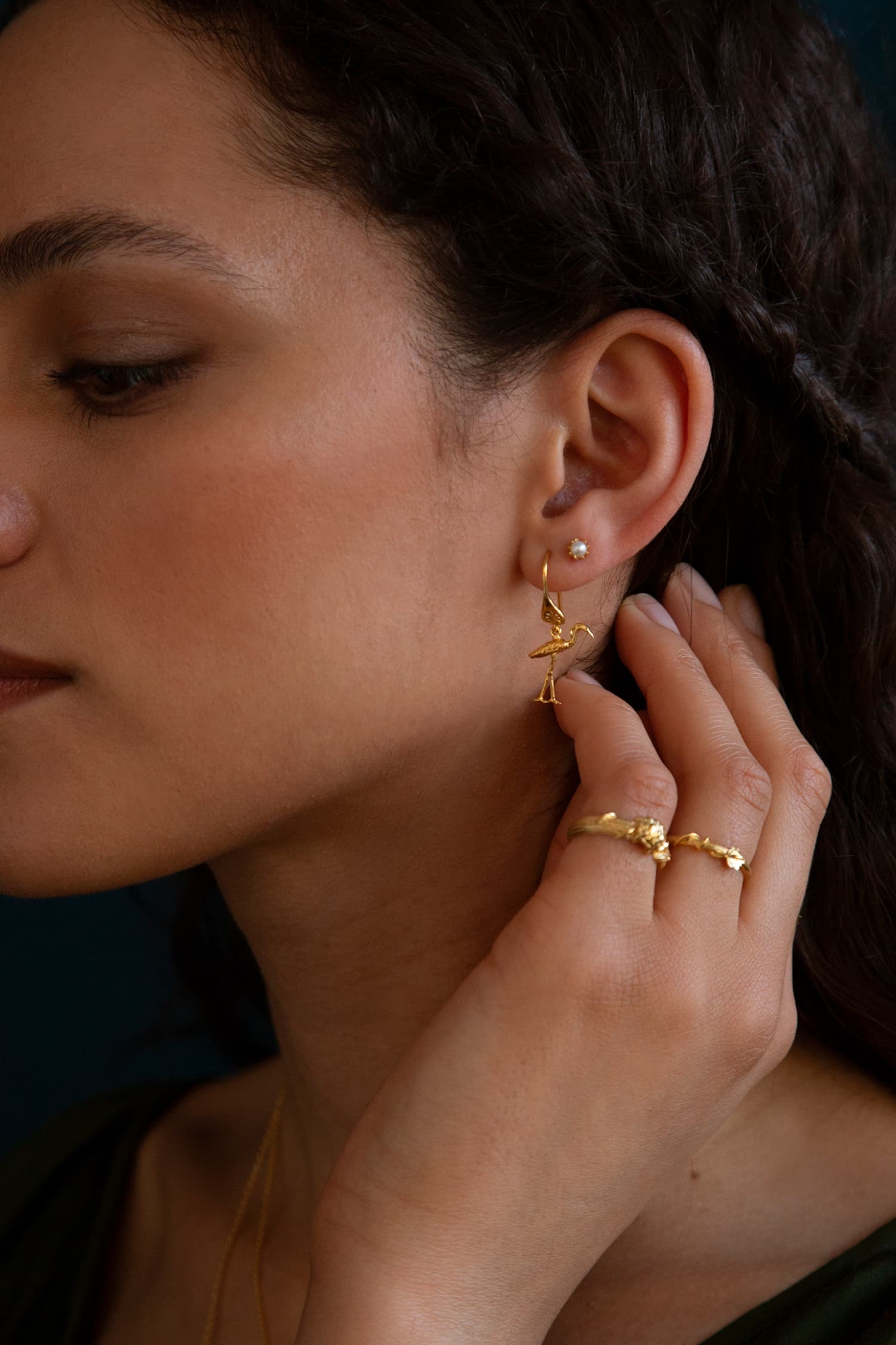 Model wears Fables Heron Ornate Hook Earrings in gold plate paired with pearl stud and column rings