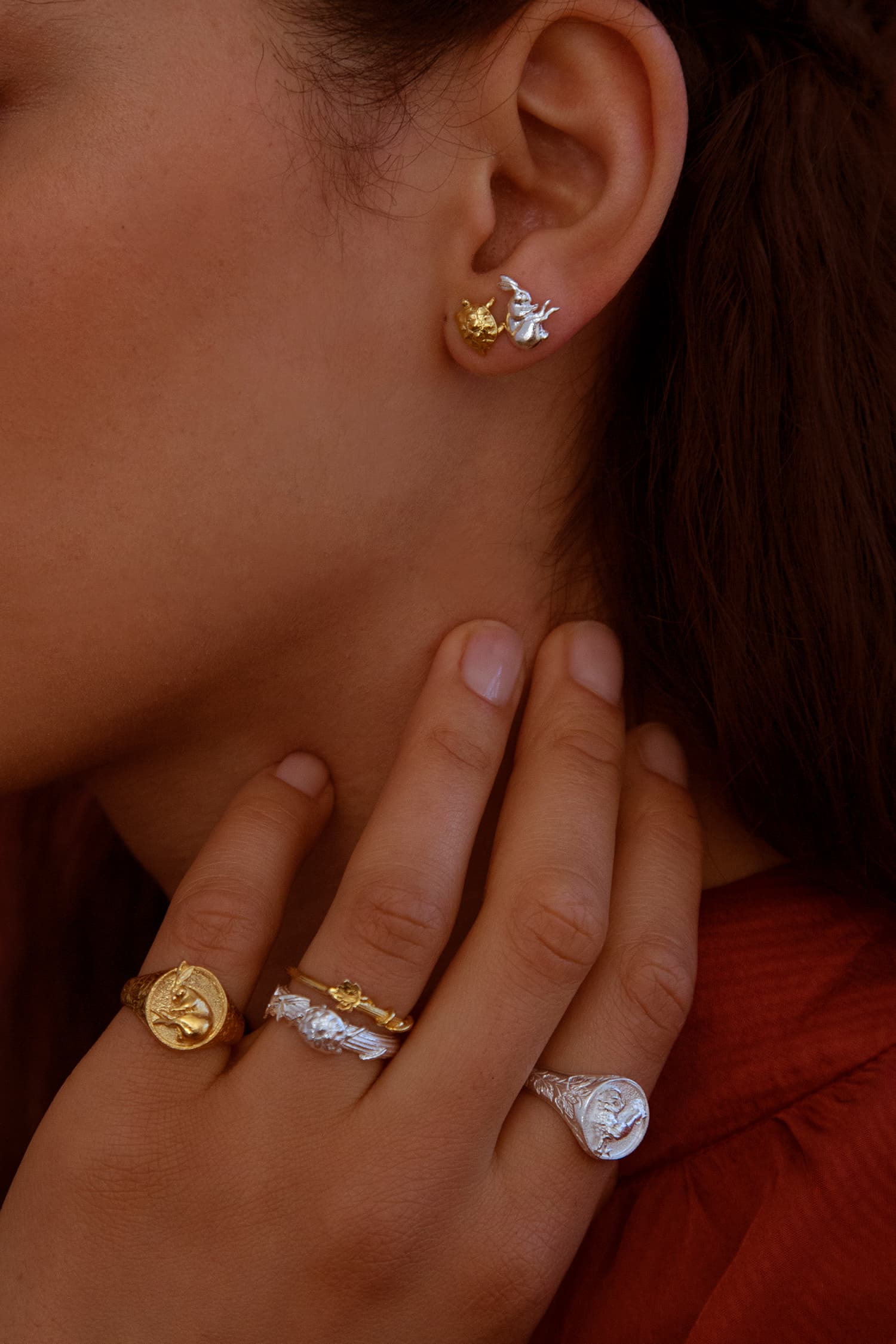 Model wears Fables Tortoise and Hare Stud earrings and selection of fables signet and fine column rings