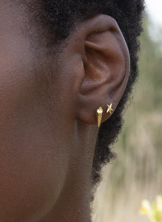 sea shell and starfish single 18ct yellow gold stud earrings worn on same ear by model