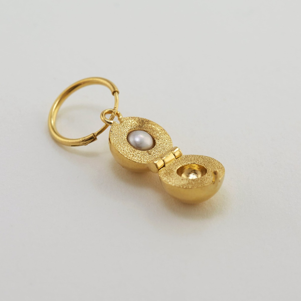Paper shot of Cannonball Opening Earring with Hidden Pearl by Alex Monroe Jewellery
