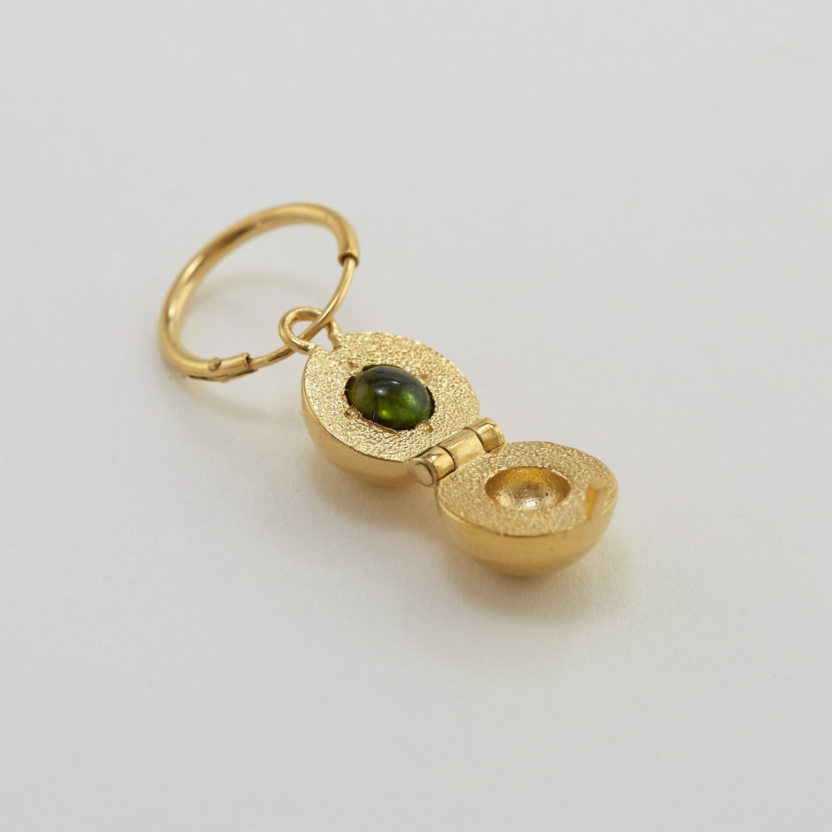  Paper shot of Cannonball Opening Earring with Hidden Green Tourmaline by Alex Monroe Jewellery