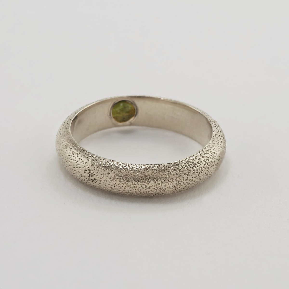 Paper shot of Hans D-Shape Hidden Green Tourmaline Ring by Alex Monroe Jewellery