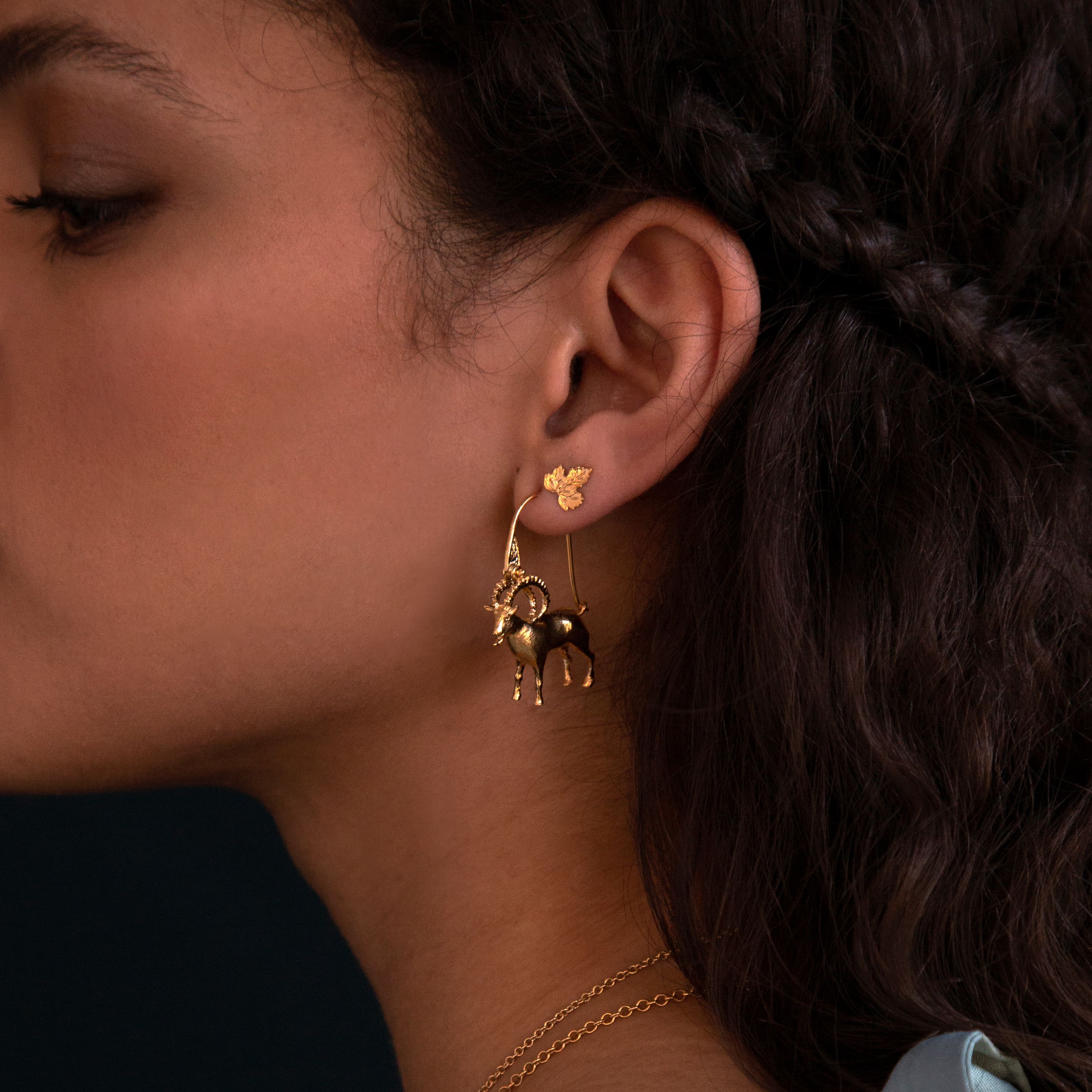 fairmined gold plated ram hook earrings and vine leaf stud earring worn by model