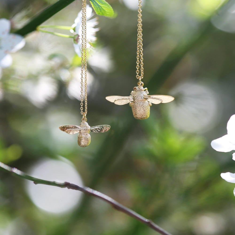baby bee and bumblebee necklace hanging from a branch