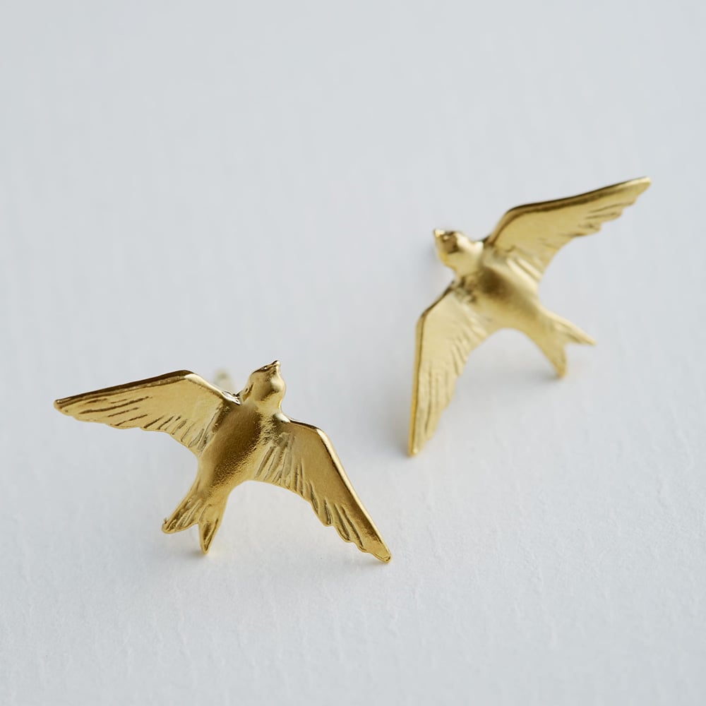 Paper shot of gold plated Flying Swallow Stud Earrings by Alex Monroe Jewellery