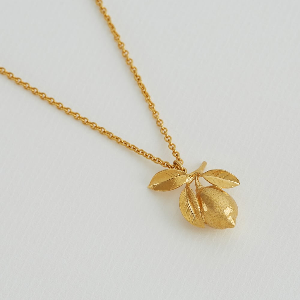 Paper shot of gold plated Large Lemon & Leaf Necklace by Alex Monroe
