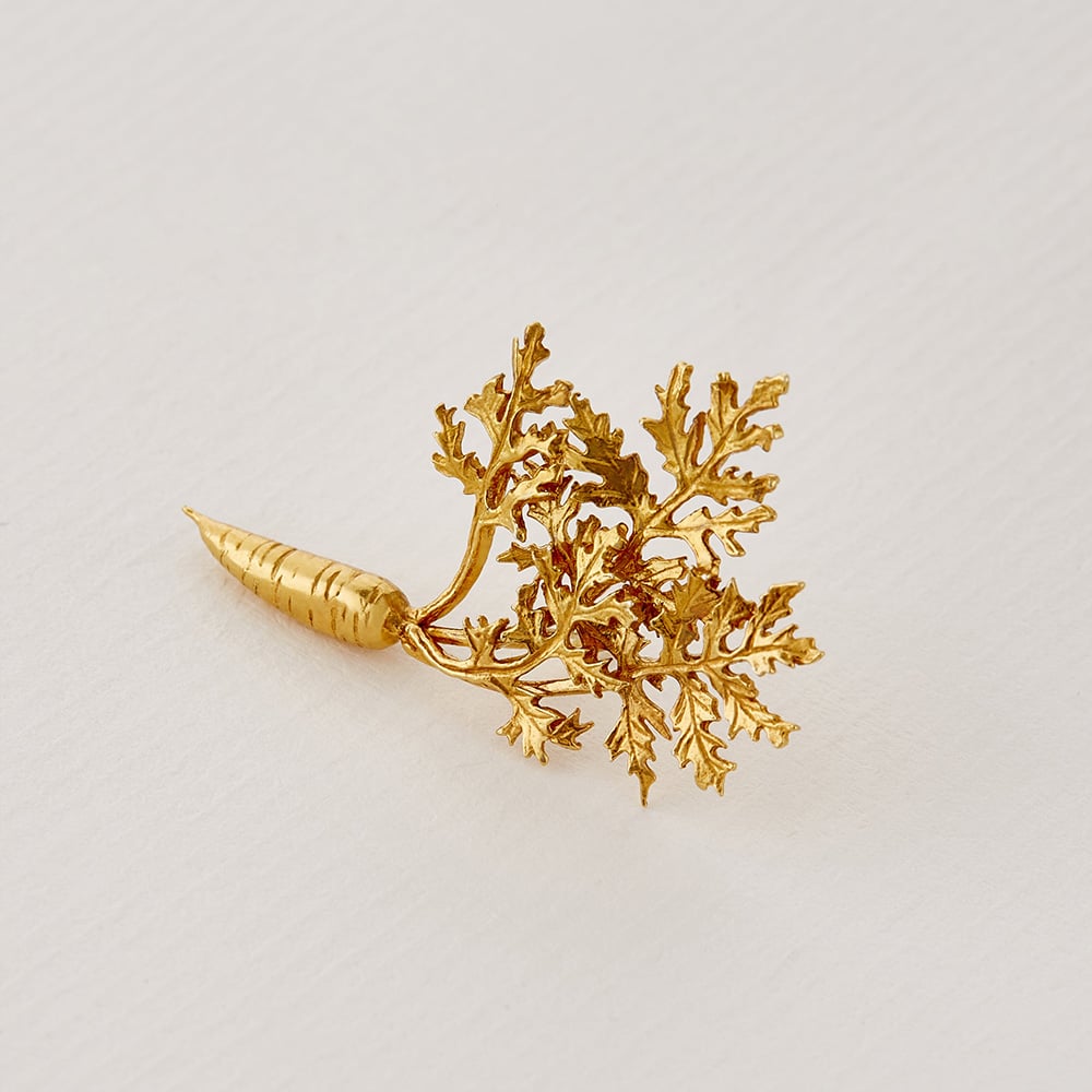 Paper shot of gold plated leafy carrot pin brooch by Alex Monroe