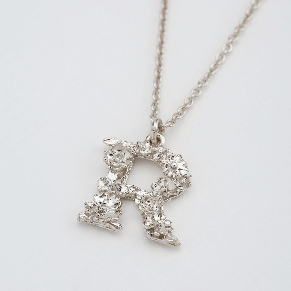 Paper shot of silver Floral Letter R Necklace by Alex Monroe Jewellery