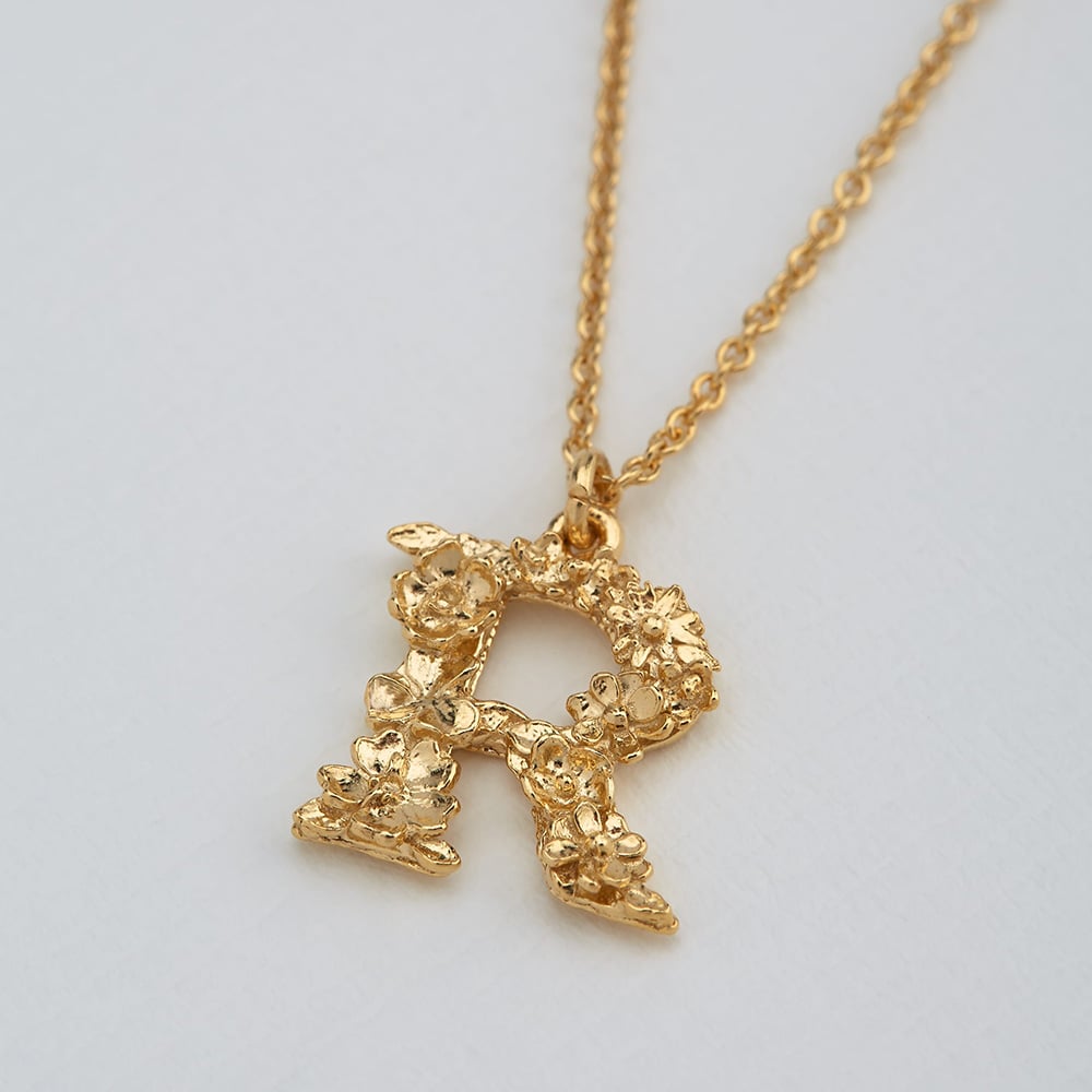 paper shot of gold plated floral letter r necklace by Alex Monroe Jewellery