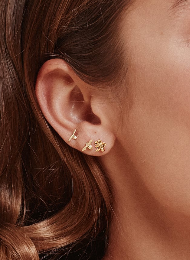 Close up of Model wearing Forget Me Not Stud Earrings with Itsy Bitsy Bee from Alex Monroe's A garden gathering Collection