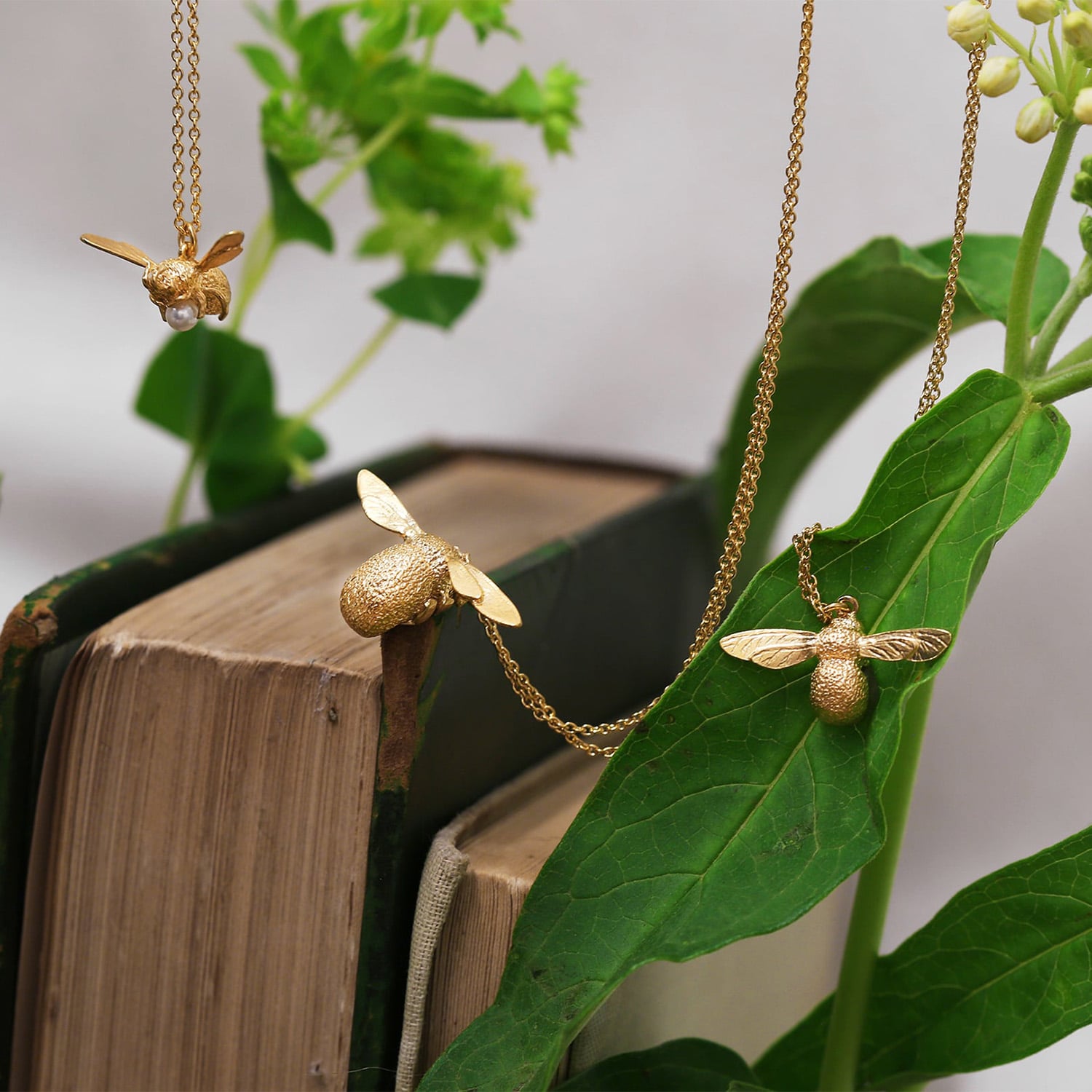 Lock and Key Necklace gold plated silver with black seed pearls displayed on vintage books with peach coloured flower