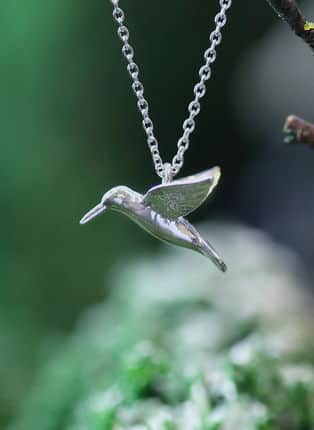 close up of a silver bee hummingbird necklace