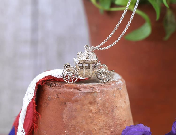 Royal Collection Trust Jubilee Carriage Silver Necklace on terracotta plant pot with flag