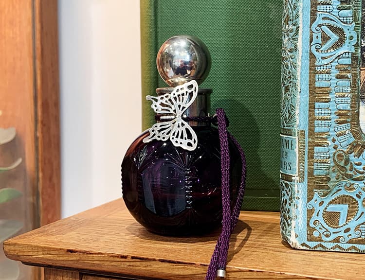 Penhaligons Purple perfume bottle with Alex Monroe silver butterfly bracelet