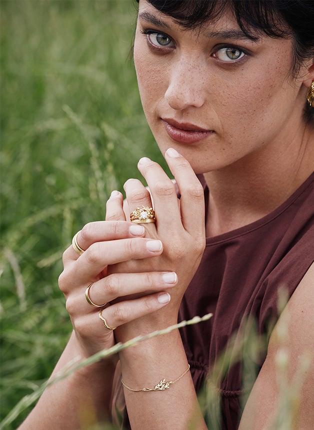 Model wearing stacking rings and a Harvest Seed Ring with 0.7ct Central Diamond by Alex Monroe Fine Jewellery