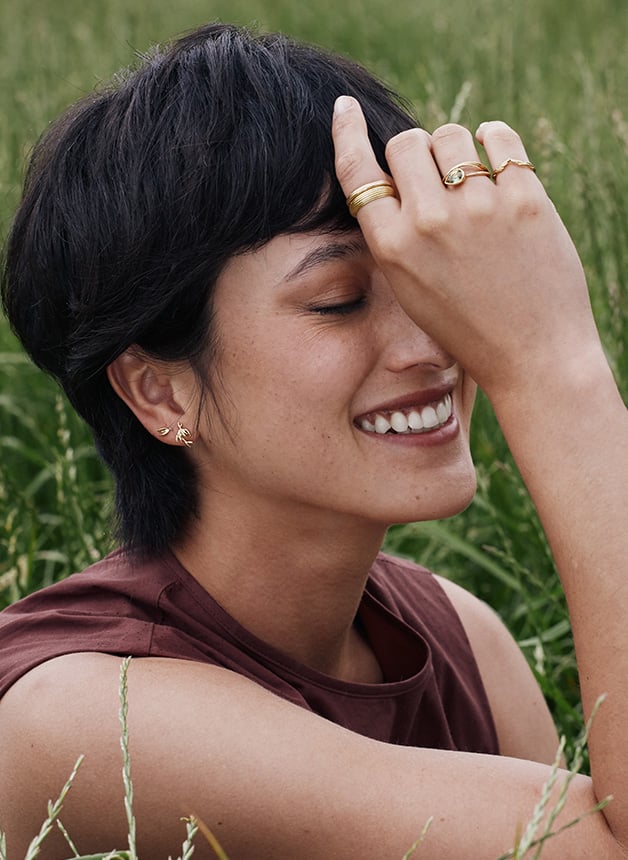 Model wearing Asymmetric Flyaway Oat Seed Stud Earrings and yellow gold fine Jewellery from Alex Monroe's Golden Harvest Collection