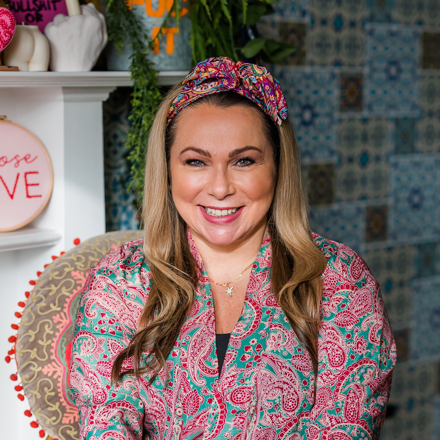 Portrait of Holly wearing a pink printed dress with a pink headband