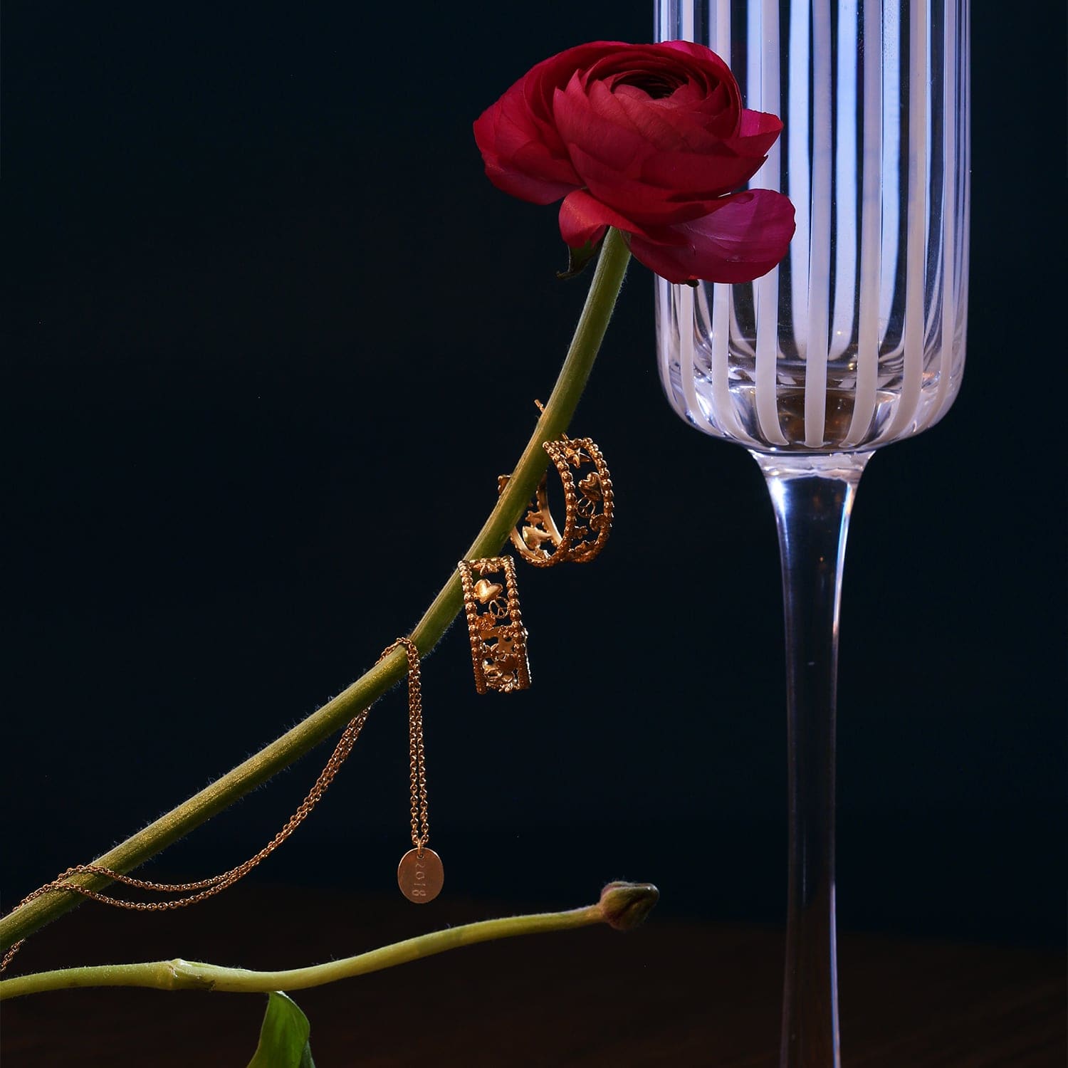 Peace and Love Wide Hoop Earrings gold plated silver displayed on single pink rose with champagne flute