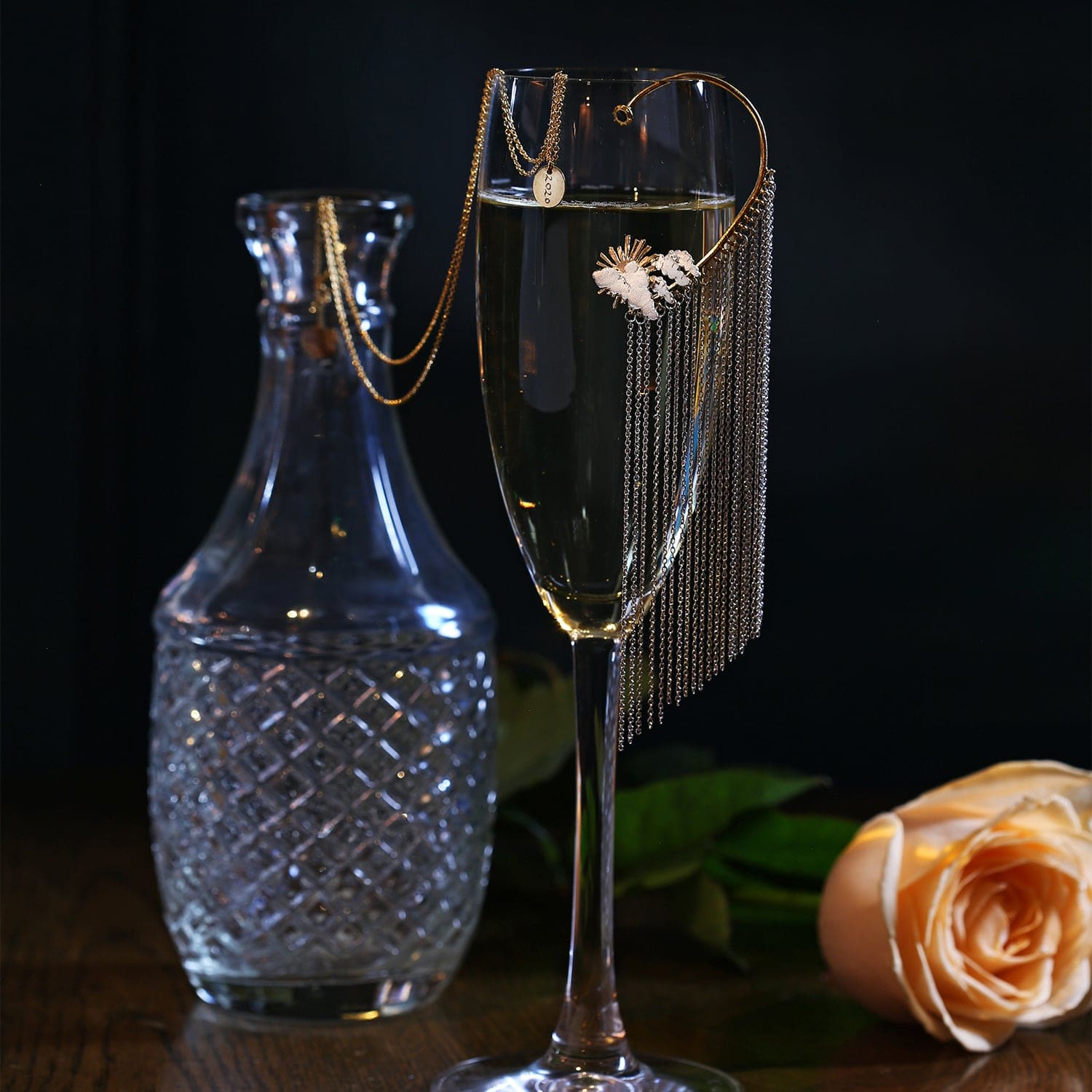 Waterfall Chain Drop Ear Cuff with Blue Topaz silver and gold plate displayed on champagne flute with peach rose