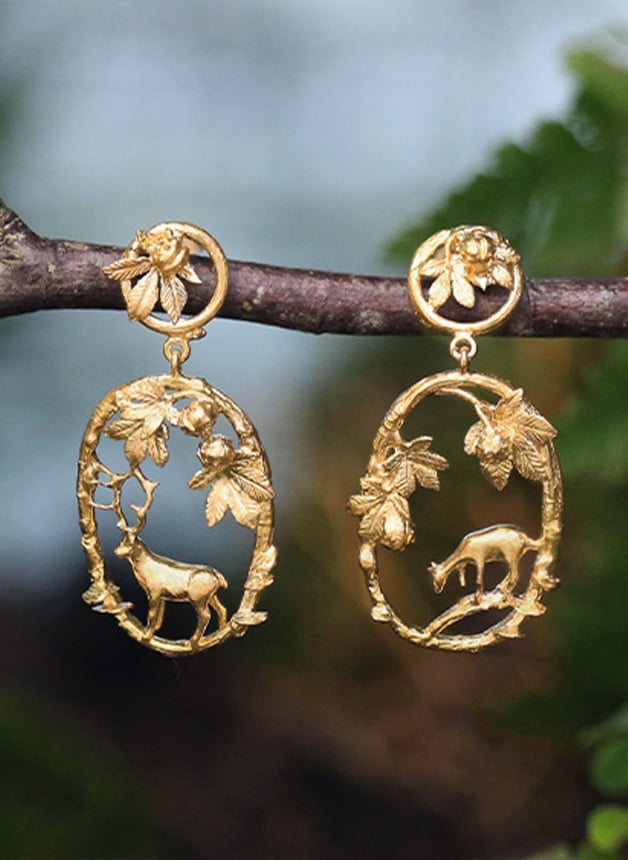 Gold plated Doe & Stag Oval Loop Drop Earrings hanging on a branch