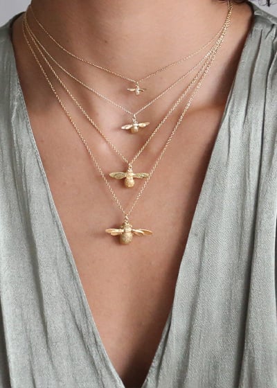 Model layering 4 gold Alex Monroe bumblebee necklaces
