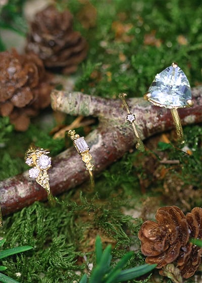 model, wearing 18ct yellow gold solitaire diamond engagement ring and textured wedding band, plus a fine twig and diamond bracelet.