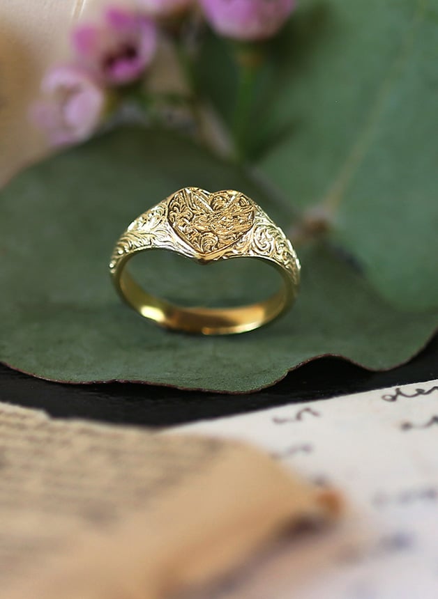 Gold plated Victoriana Heart Signet Ring placed on a green leaf