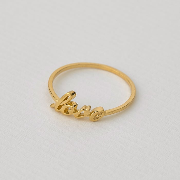 Paper shot of a gold plated Handwritten 'Love' Ring by Alex Monroe Jewellery
