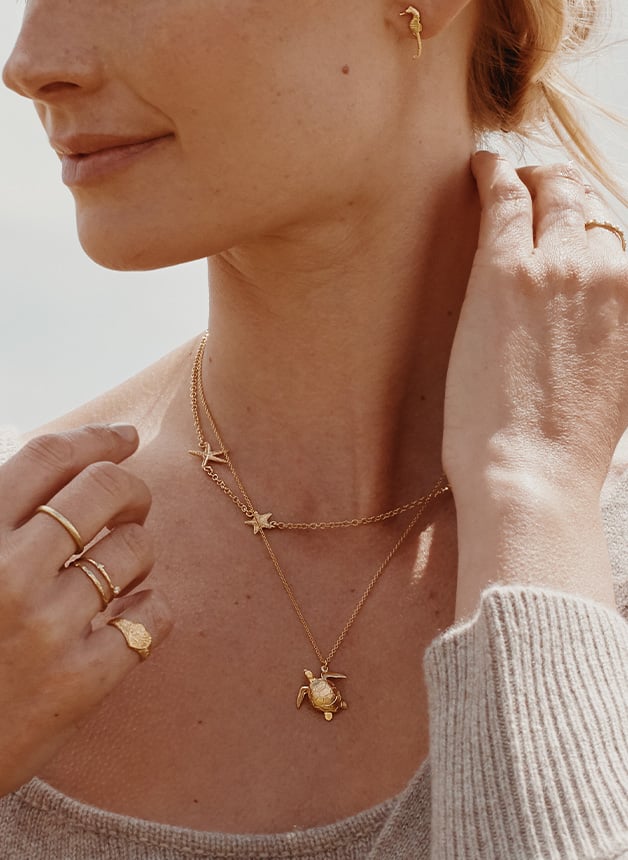  model wearing gold plated Dragonfly Necklace and Vintage Bicycle Necklace with Gemstone Lights by Alex Monroe Jewellery