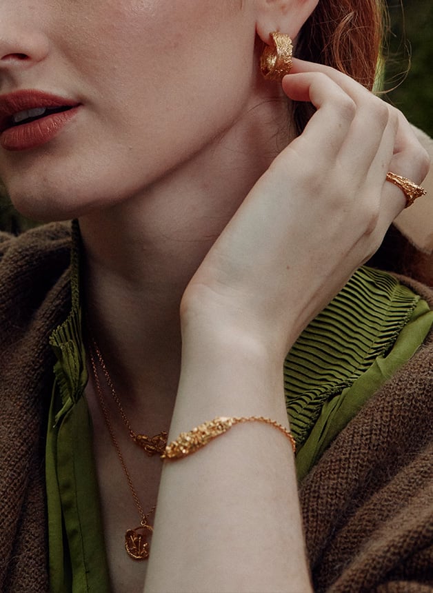 Model wearing gold plated Woodland Bark Inline ID Bracelet by Alex Monroe Jewellery
