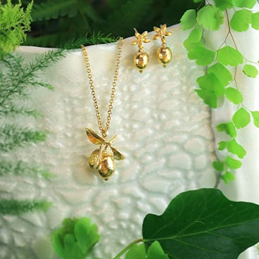 Daisy, gold plated floral heart and silver leaf earring placed on flower vases