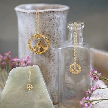 Daisy, gold plated floral heart and silver leaf earring placed on flower vases