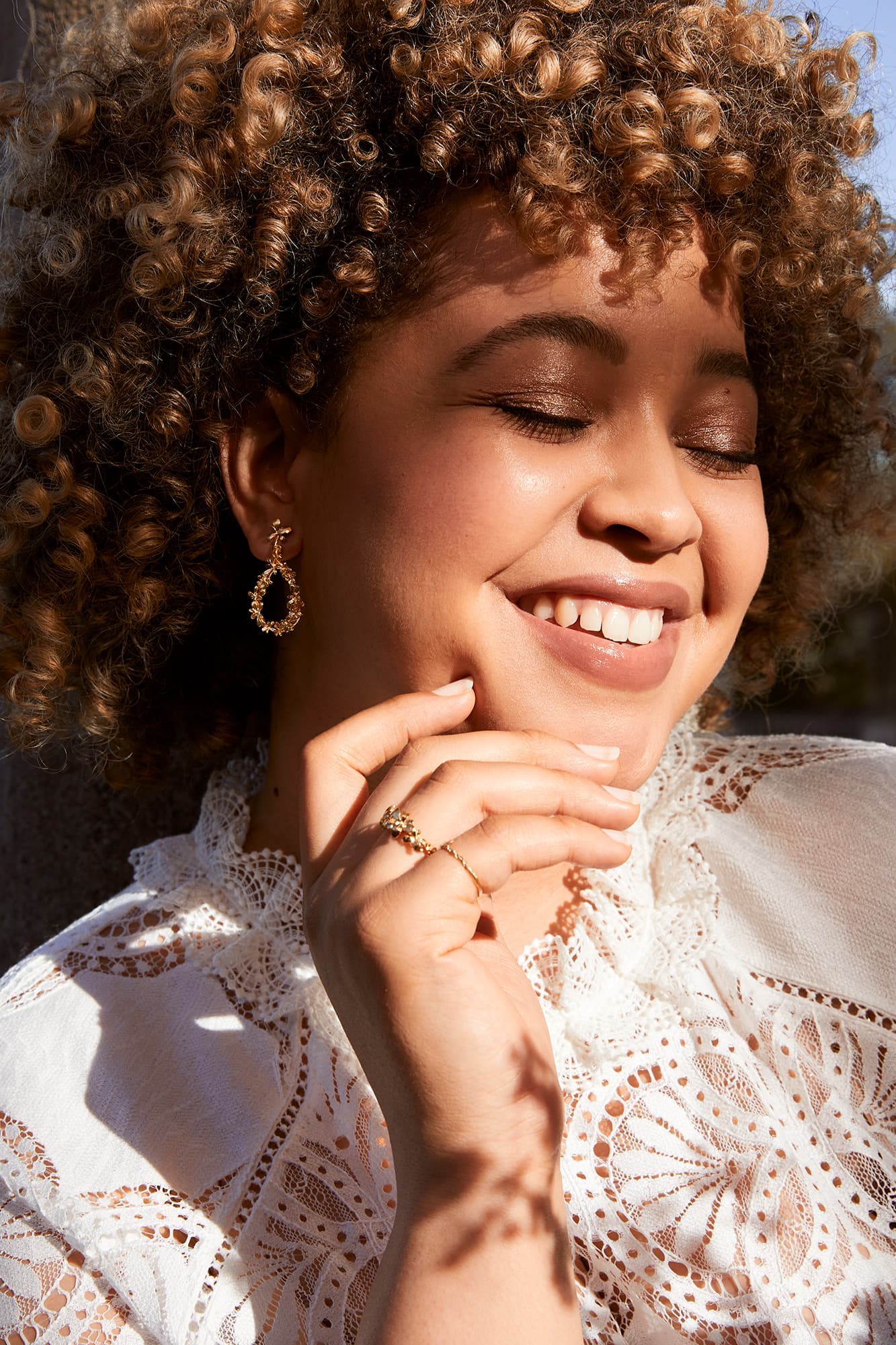 Smiling Model wears Humble Beginnings Sprouting Rosette Teardrop Earrings silver with 22ct fairmined gold plate