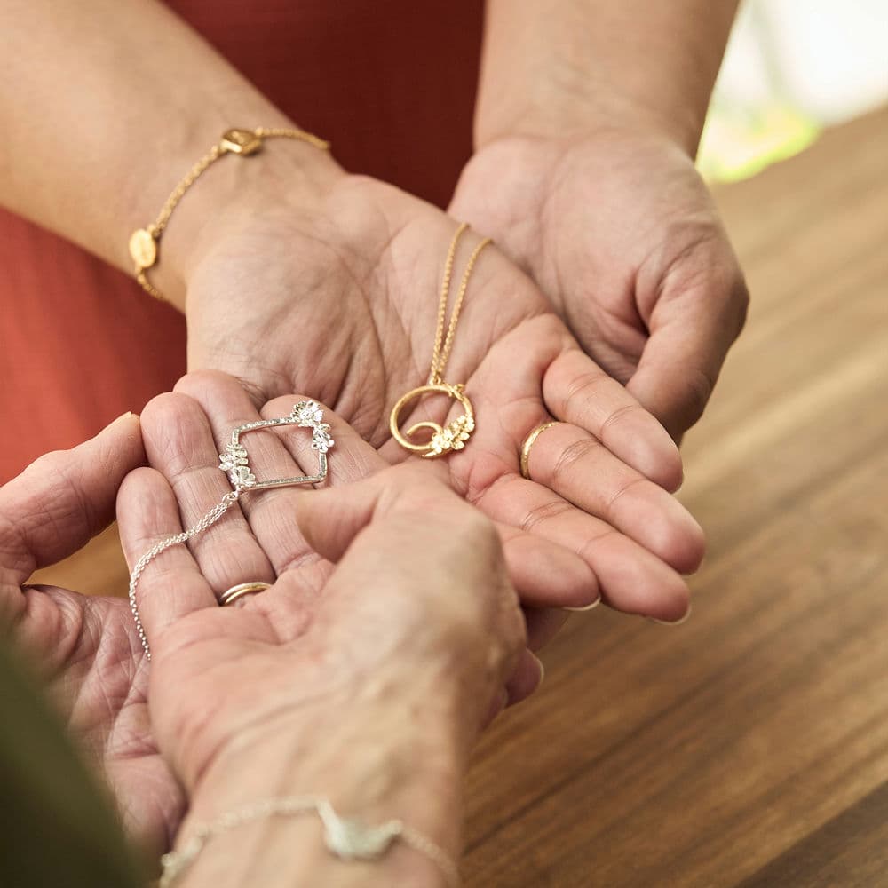Jan and Naomi hugging, wearing their Alex Monroe Jewellery School Necklace creations.