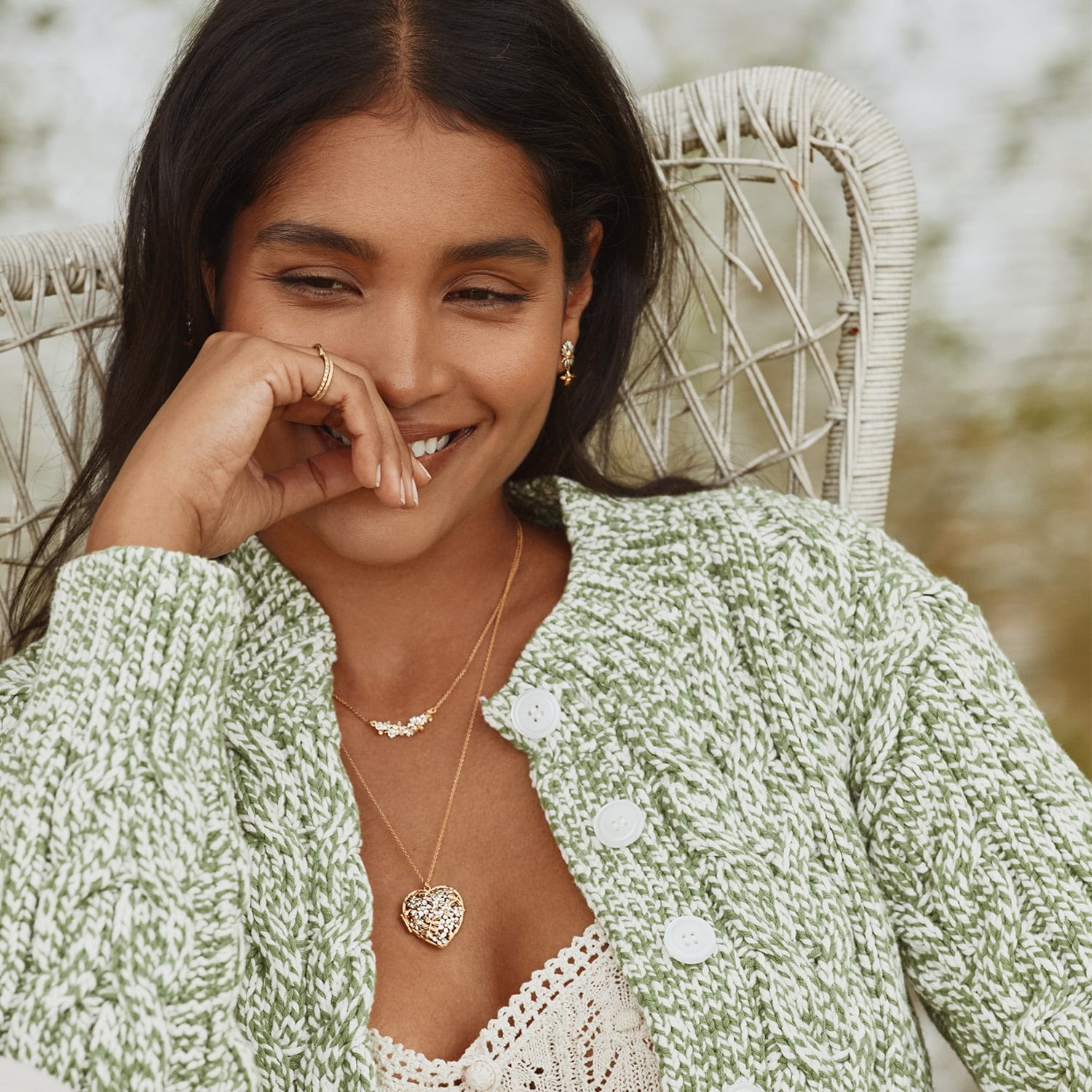 Model wearing in-line garden gathering necklace with Itsy bitsy bee and posy heart necklace by Alex Monroe Jewellery