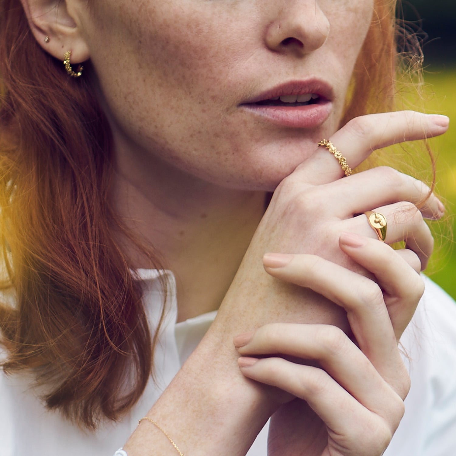 Model wearing 18ct gold Itsy Bitsy Daisy Fine Wreath Ring with Single Bee and bee signet ring by Alex Monroe Jewellery