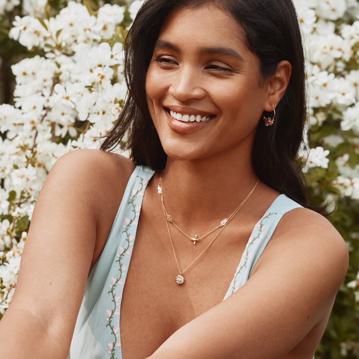 model wearing Alex Monroe floral chain necklace with Teeny Tiny Bee, gold-plated with silver details