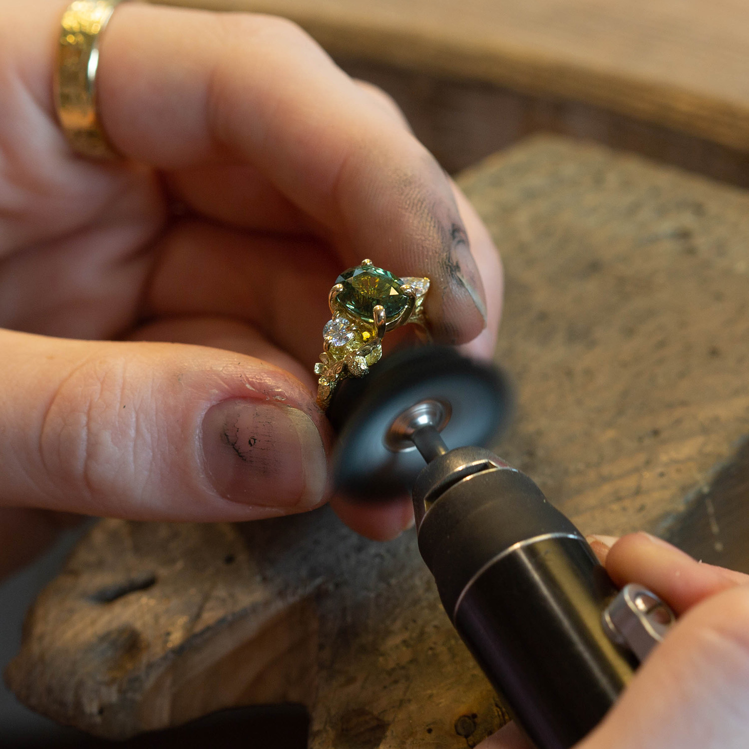 Alex Monroe Jewellery one of a kind bespoke large diamond and green sapphire ring being polished in Alex Monroe's Snowsfields workshop