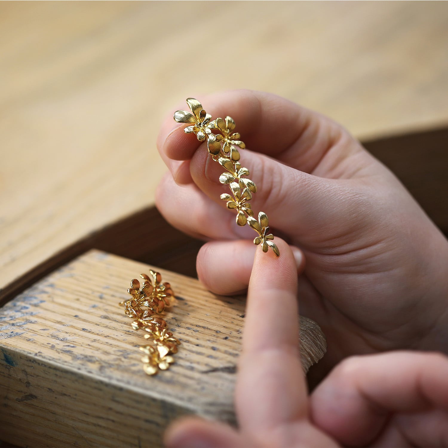 Gold Platted Large Rosette Flourish Drop Earrings being worked on in Alex Monroe's workshop