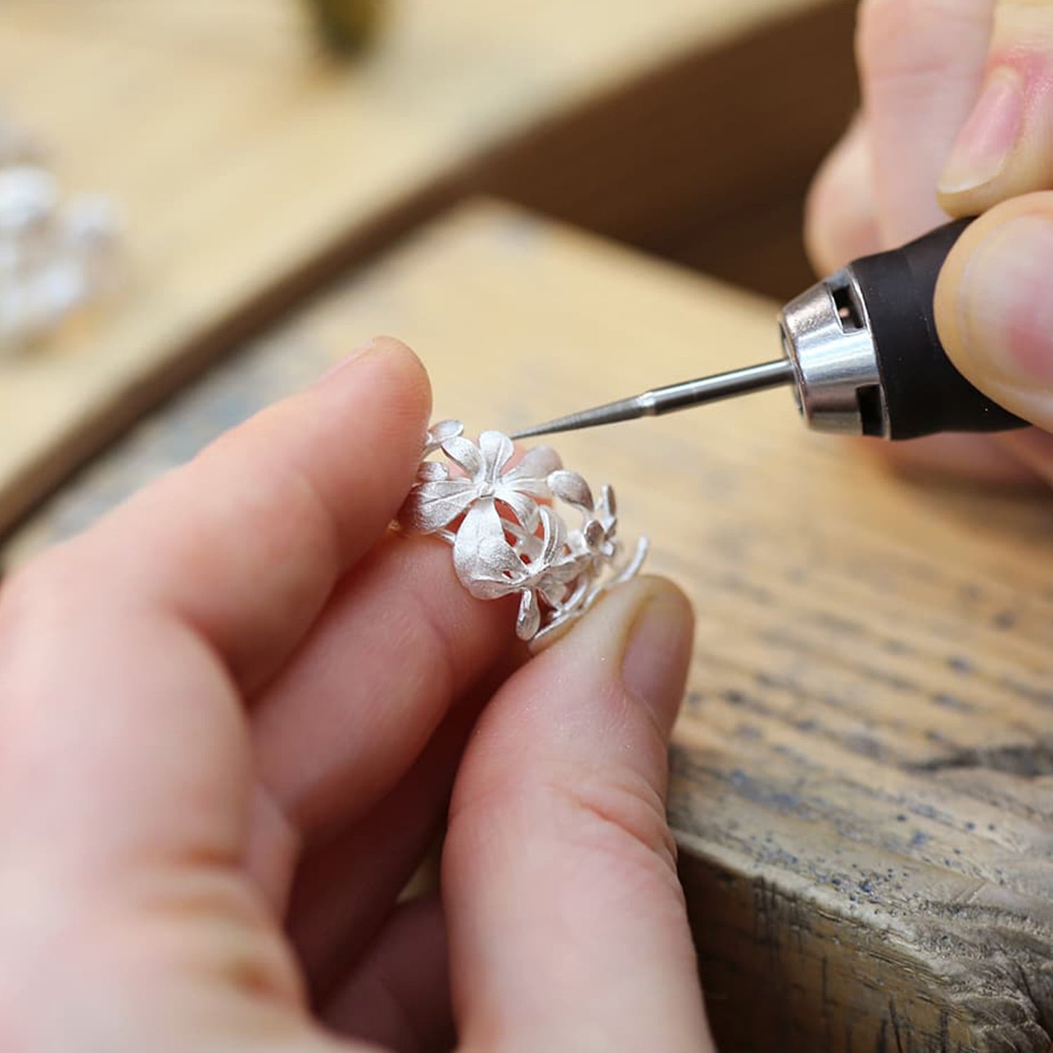Jeweller making sterling silver huggie earrings by Alex Monroe jewellery