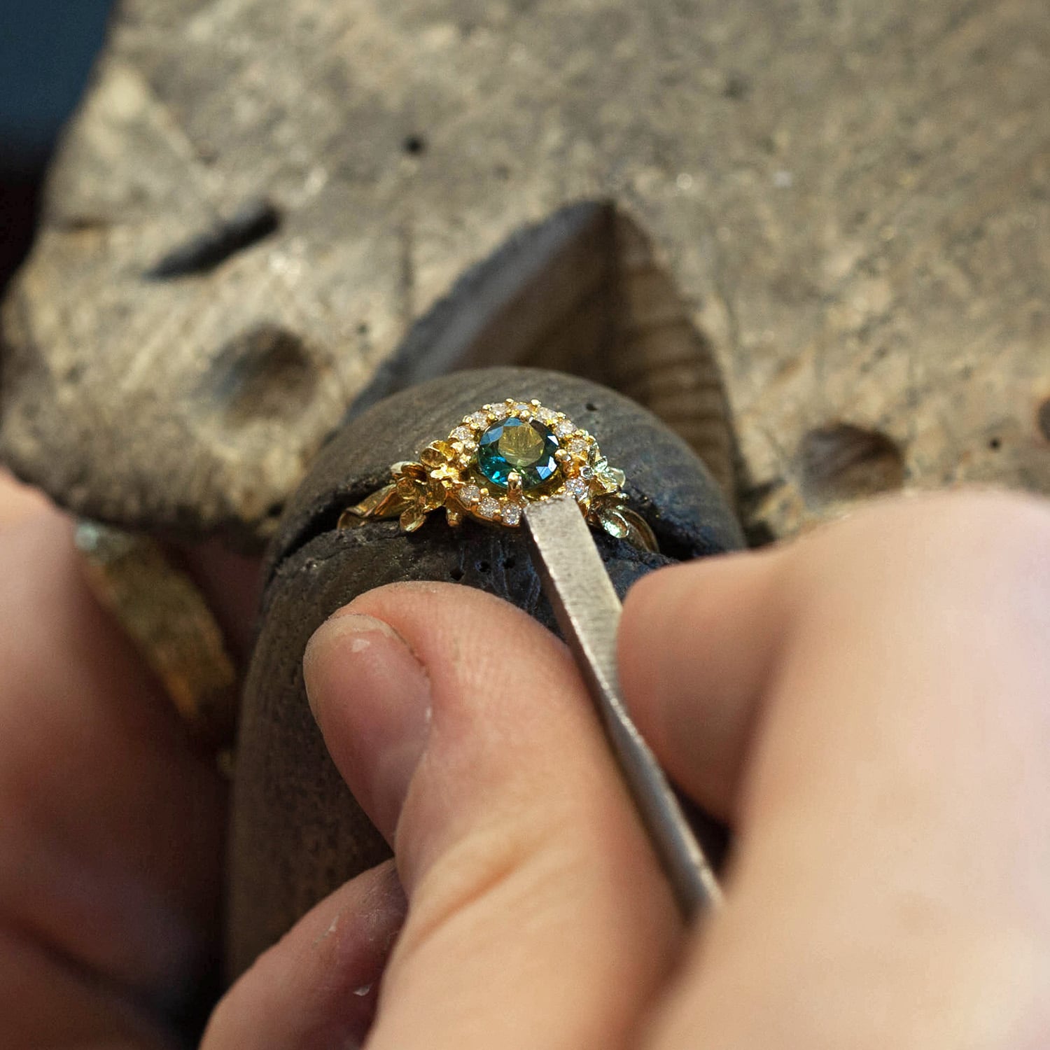 Jeweller working on One of a Kind green sapphire and diamond large halo ring by Alex Monroe Jewellery